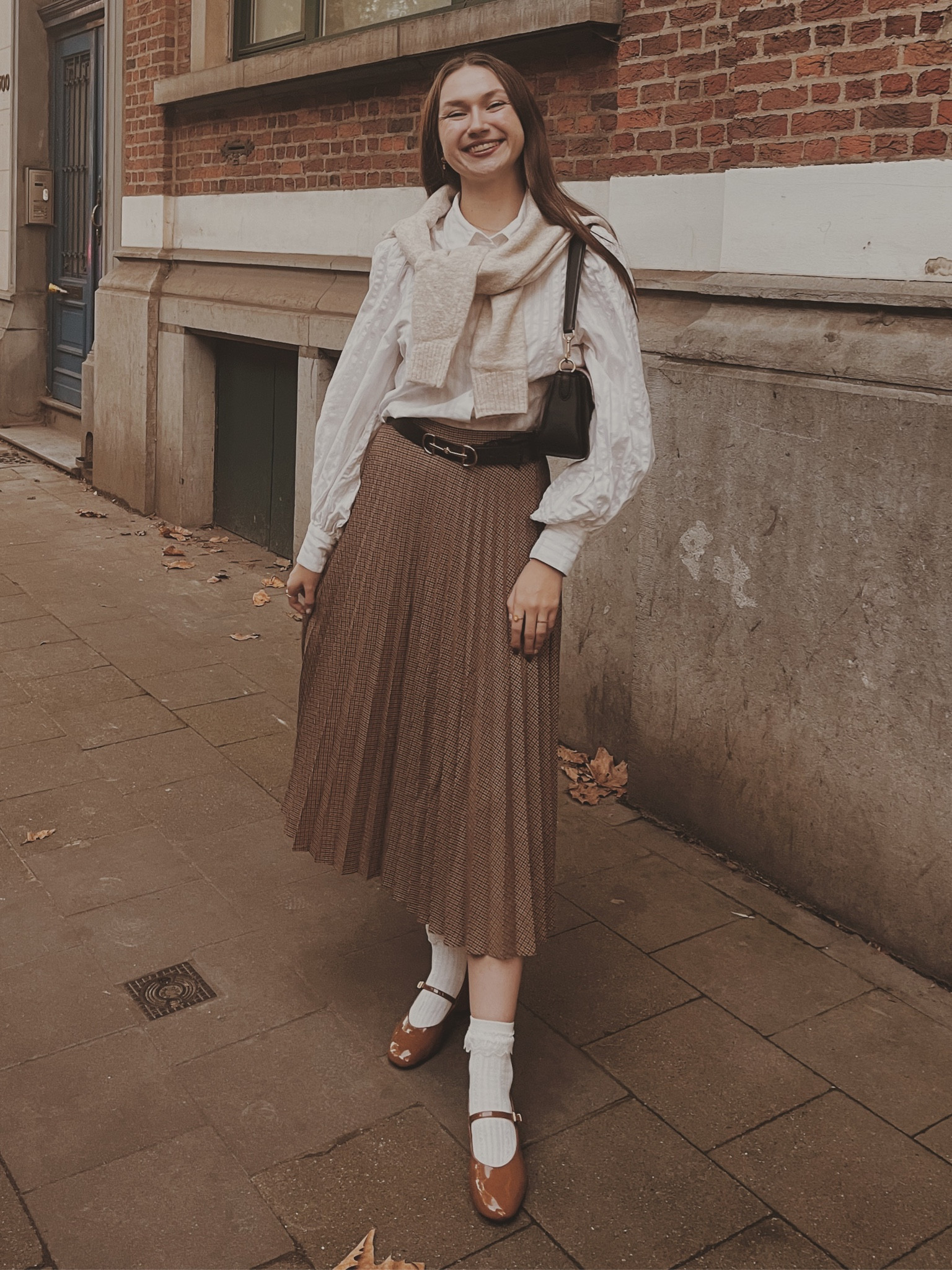 White shirt
Beige cardigan 
Dark brown belt with horsbit buckle 
Frill socks

Light academia 
Light academia outfit 
Light academia style 
Light academia aesthetic 
Neutral outfit 
Autumn outfit 
Autumn fashion 
Autumn fashion inspo