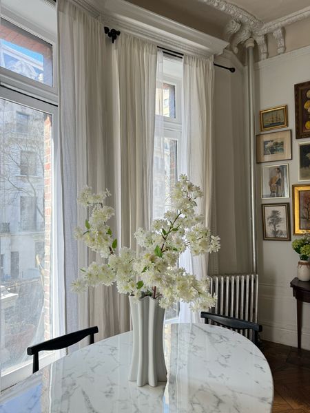 Faux cherry blossoms, fluted vase, linen curtains, marble dining table, black dining chairs 

#LTKhome