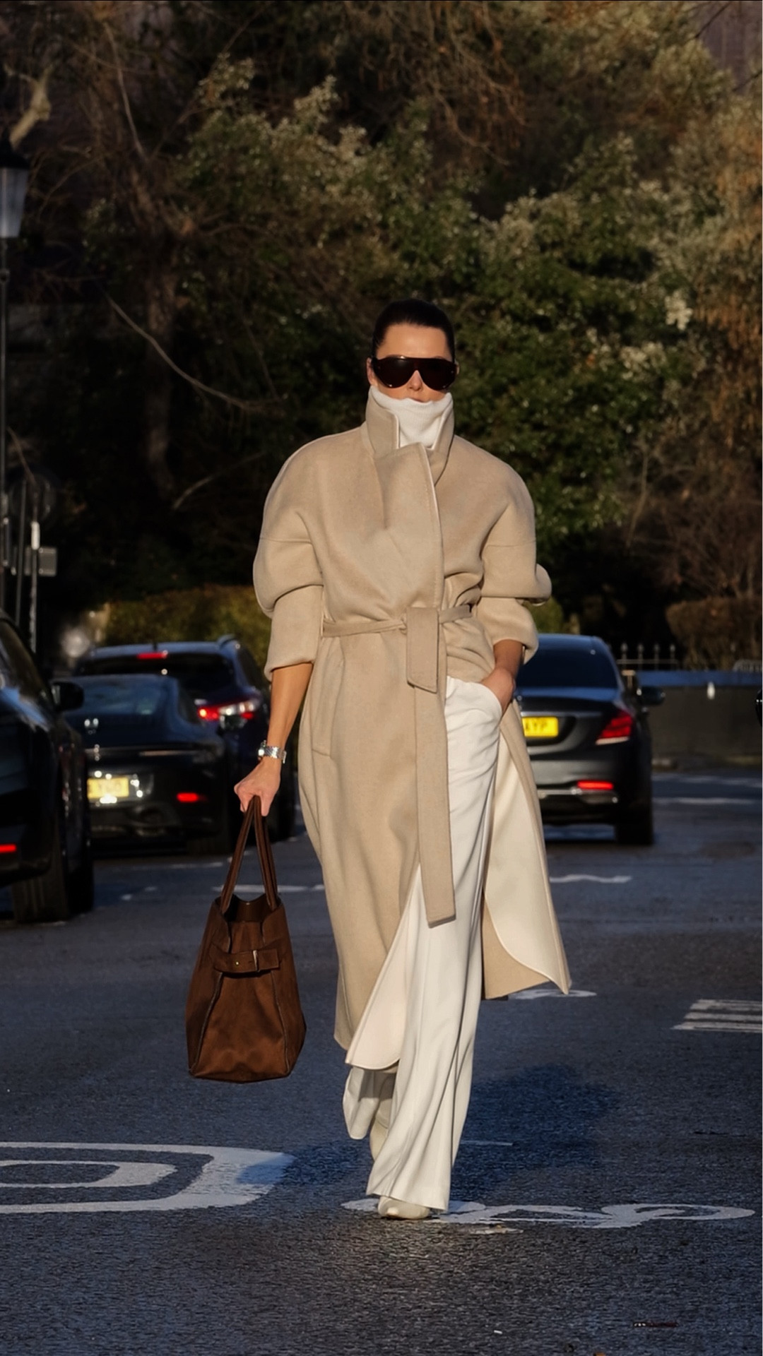 Four winter looks, all shoppable.

Look 1
Ivory trousers styled with a beige wool coat, brown suede tote, ivory ankle boots, and oversized aviator sunglasses.

Look 2
White tapered trousers with a black roll neck, black suede knee-high boots, a thick black belt, grey wool pea coat, and oversized aviator sunglasses.

Look 3
White tapered trousers paired with a taupe roll neck, brown long wool coat, brown knee-high stiletto boots, a wide brown belt, brown suede gold-handled clutch, and oversized sunglasses.

Look 4
A black roll neck with black straight-leg jeans, black ankle boots, a thin black belt, black fur scarf, black Toteme lock bag, oversized sunglasses, and an oversized belted blazer.

#LTKuk #LTKwinter #LTKeurope