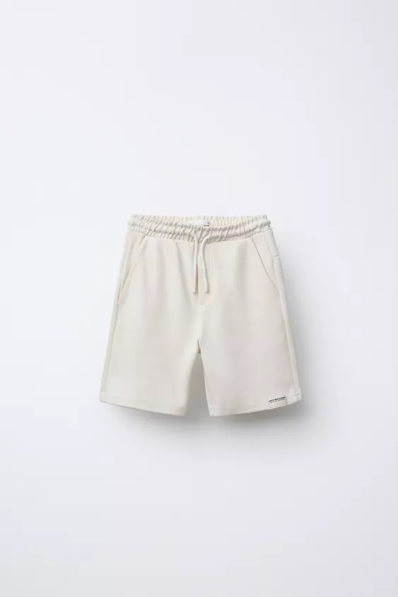 Shorts with elastic waistband and front drawstring appliqué. Front pockets and back patch pocket... | Zara US