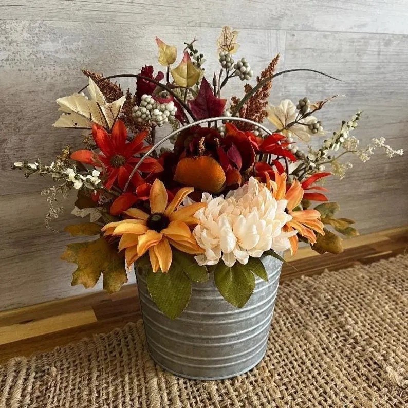 Add a cozy farmhouse touch to your space with this Fall Floral Arrangement by allthatrusticandmore 🍂🌻 Featuring a charming farmhouse bucket filled with a warm mix of autumn florals and finished with ribbon detail, this petite centerpiece brings instant seasonal cheer to any room. Perfect for your kitchen counter, entryway, or coffee table, it’s a beautiful way to celebrate fall in rustic style! 🍁 #FallDecor #FarmhouseStyle #EtsyHome #AutumnVibes #RusticDecor #CozyHome #allthatrusticandmore #LTKHome #LTKFall #SeasonalDecor

#LTKFindsUnder50 #LTKSeasonal #LTKHome