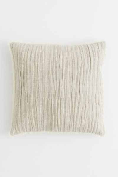 Conscious choice  Crinkled cushion cover in a soft, woven linen and cotton blend with raw-edge fr... | H&M (US + CA)