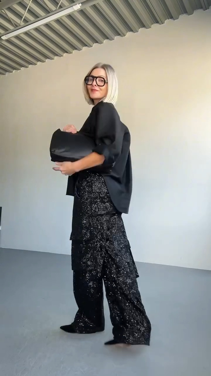 A study in contrast: shine vs. structure, statement vs. restraint. Sequins set the tone… but it’s the shape that sets the balance.

I paired slouchy sequin trousers with a sharp, structured shirt, anchored it with a sleek clutch, and added one of my favorite tension points: oversized black optical frames.

Not exactly subtle. But not loud either. Just enough sharpness to steady the shimmer.

📍Style tip: Pair bold textures or volume (like sequins or oversized shapes) with tailored layers to bring it back into focus.

#over40 #over50 #styleover40 #styletip #sequinpants #toteme #blackonblackootd #elisajohnson #mango #oldceline