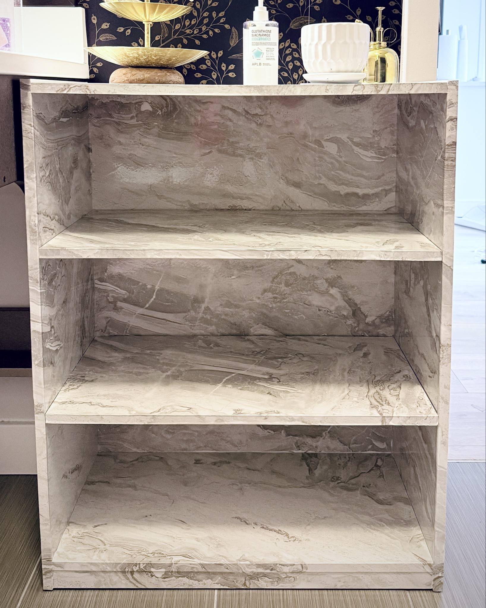 Saving for my future home so I’m giving my boring 4 year old furniture a ✨makeover. This bookcase was originally white but I want a little more pizzazz against my wallpaper.

I used contact paper—basically adhesive wrapping paper that you can apply to any smooth surface for a fresh coat and life. This marble pattern is glossy with gold accents and easy to wipe clean🙌🏼 

I love the look already and am considering doing the same for the cabinets? What do you think, should I?🤔

#LTKHome #LTKdayinmylife #LTKstorytime