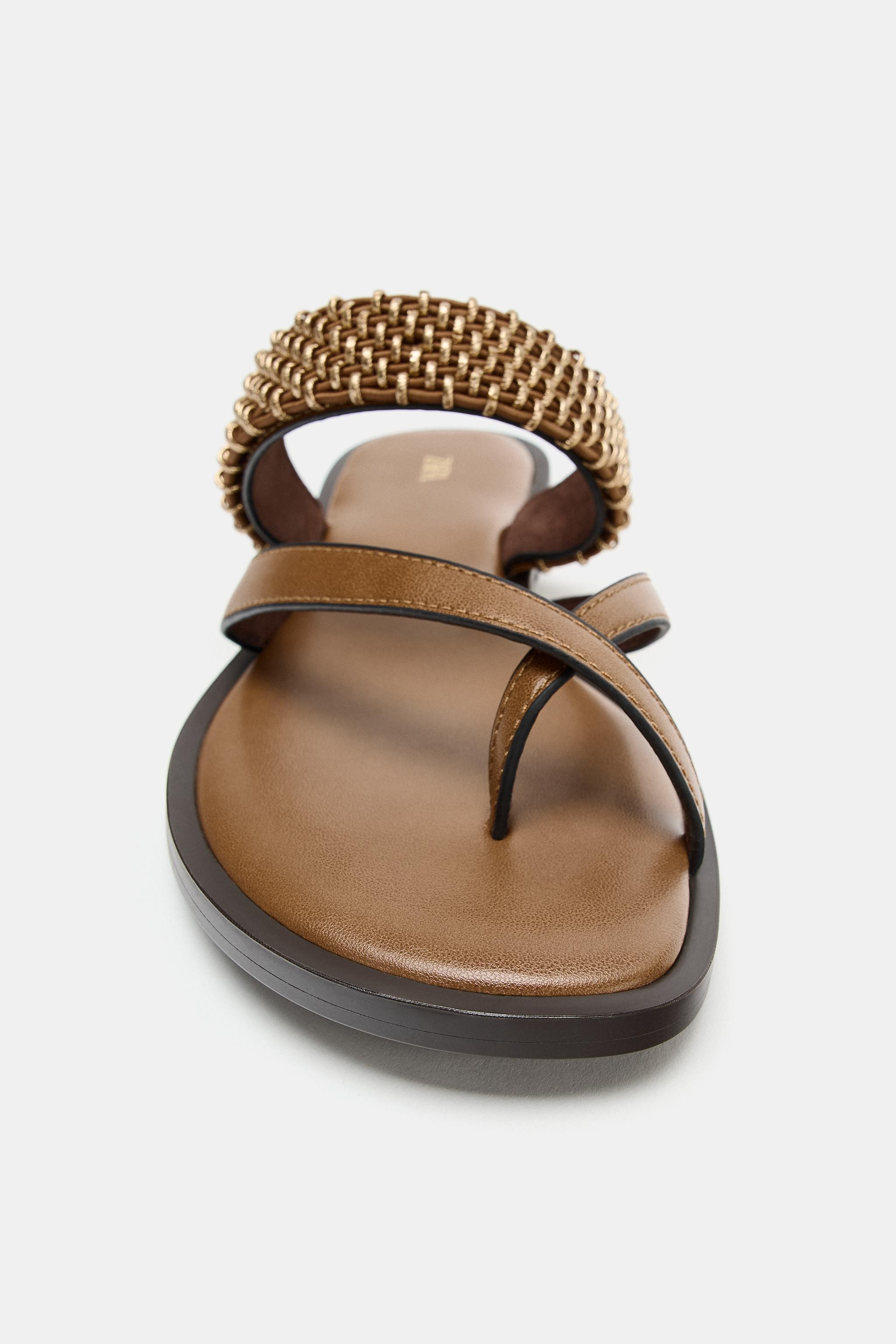 Model height: 176 cmFlat sandals. Strap across the instep with metal details and crossed strap wi... | Zara FR