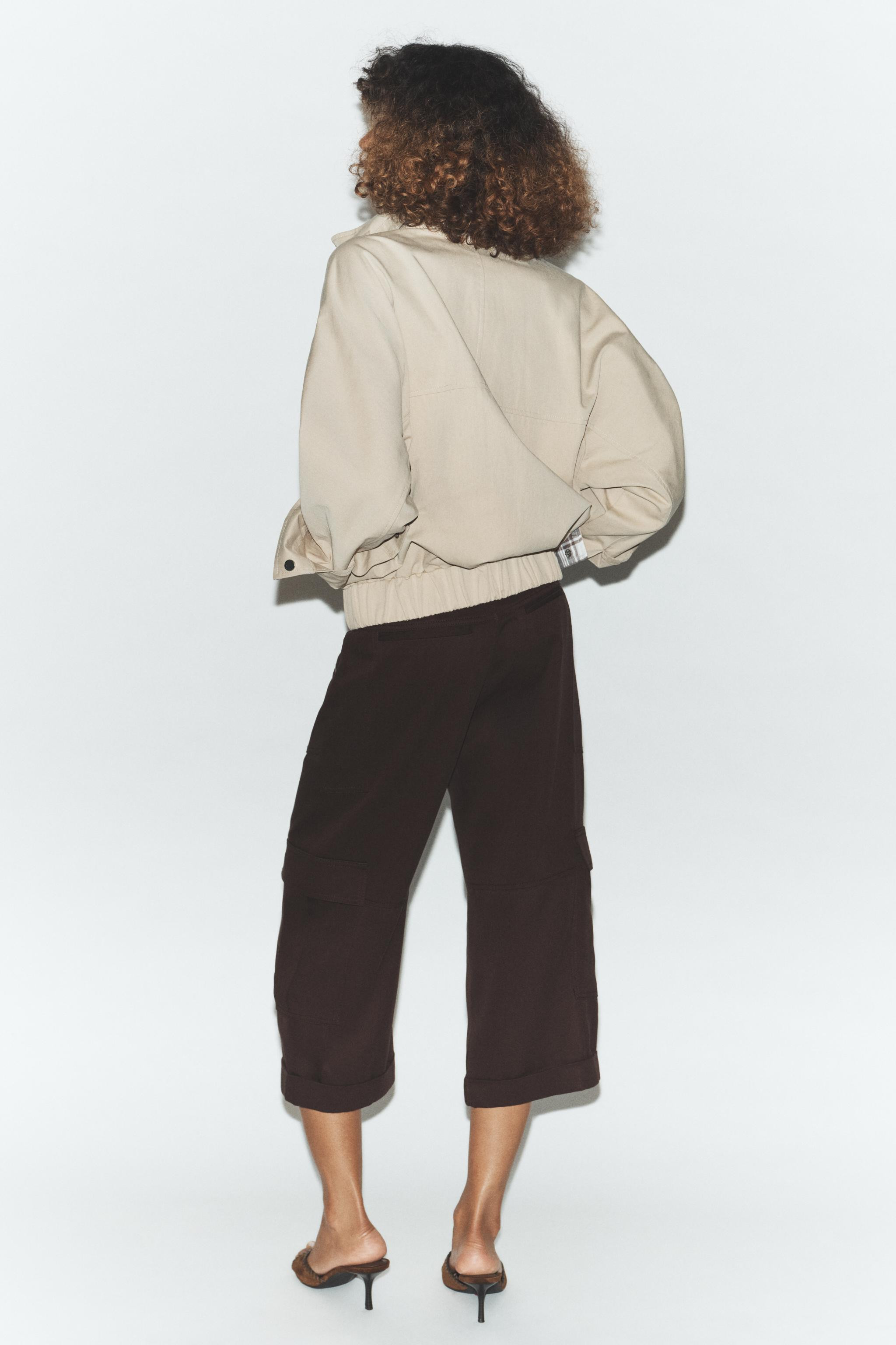 Roomy bomber jacket with a high collar, tab and buckle. Long sleeves. Front flaps and pockets. El... | Zara US