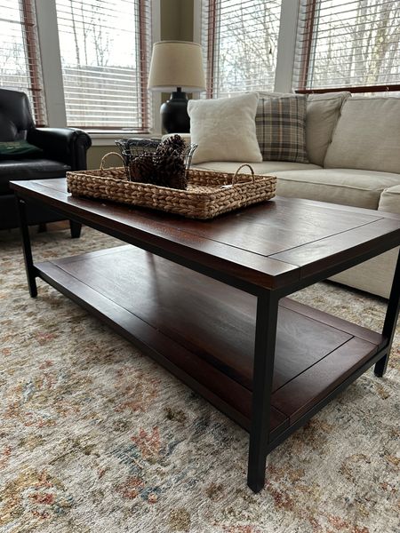 Classic wood and black metal coffee table.  Rectangle coffee table with bottom shelf. Works with traditional style, farmhouse style or even industrial style home decor.  Matching end tables with large black table lamp. Throw pillows in white faux fur and gray plaid in background.

#LTKstyletip #LTKhome