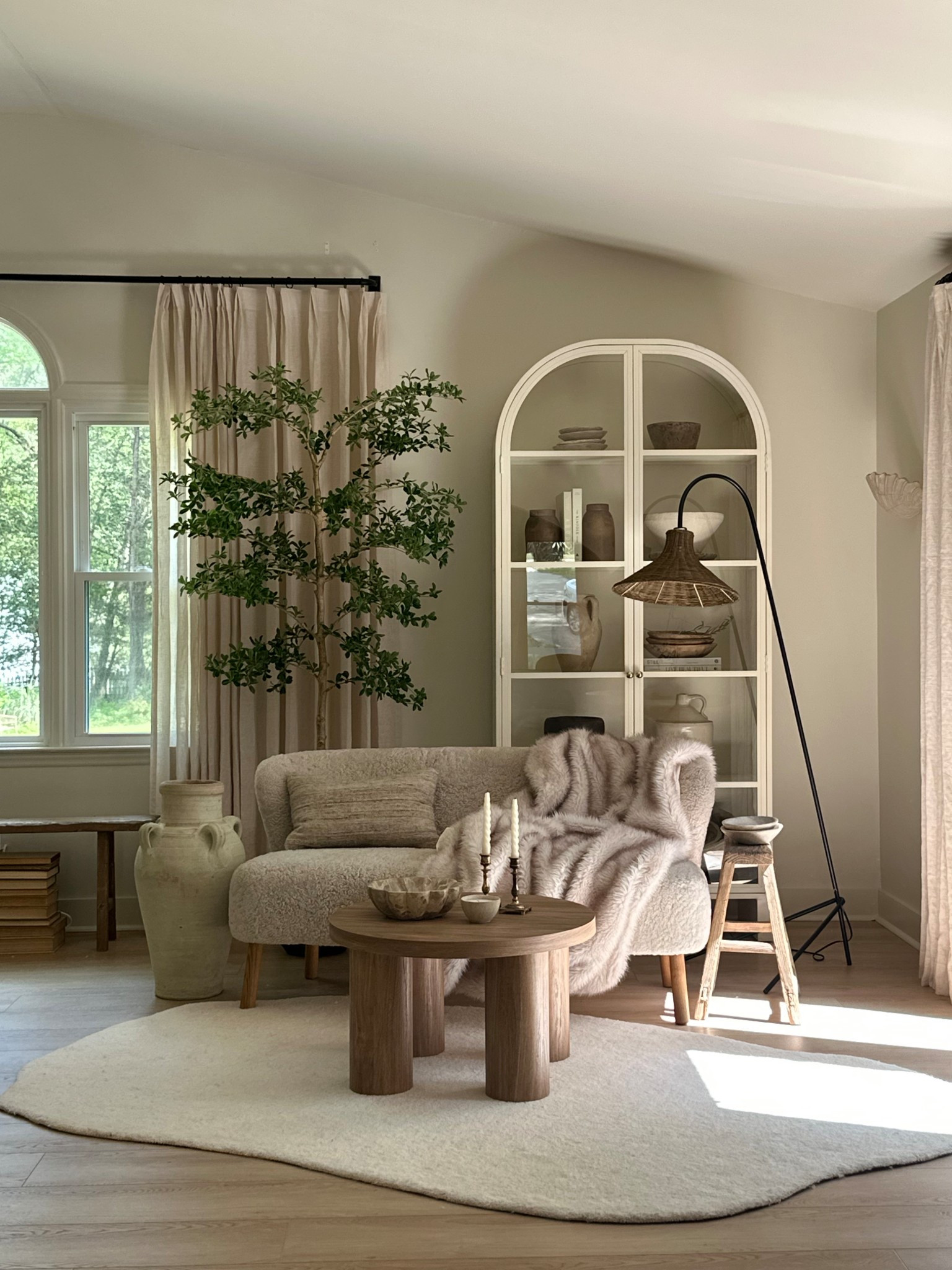 Sitting area 😍

Arched cabinet 
Coffee table 
Floor lamp 
Faux tree 
Side table 
Rug 
Pillow 
Throw Blanket 