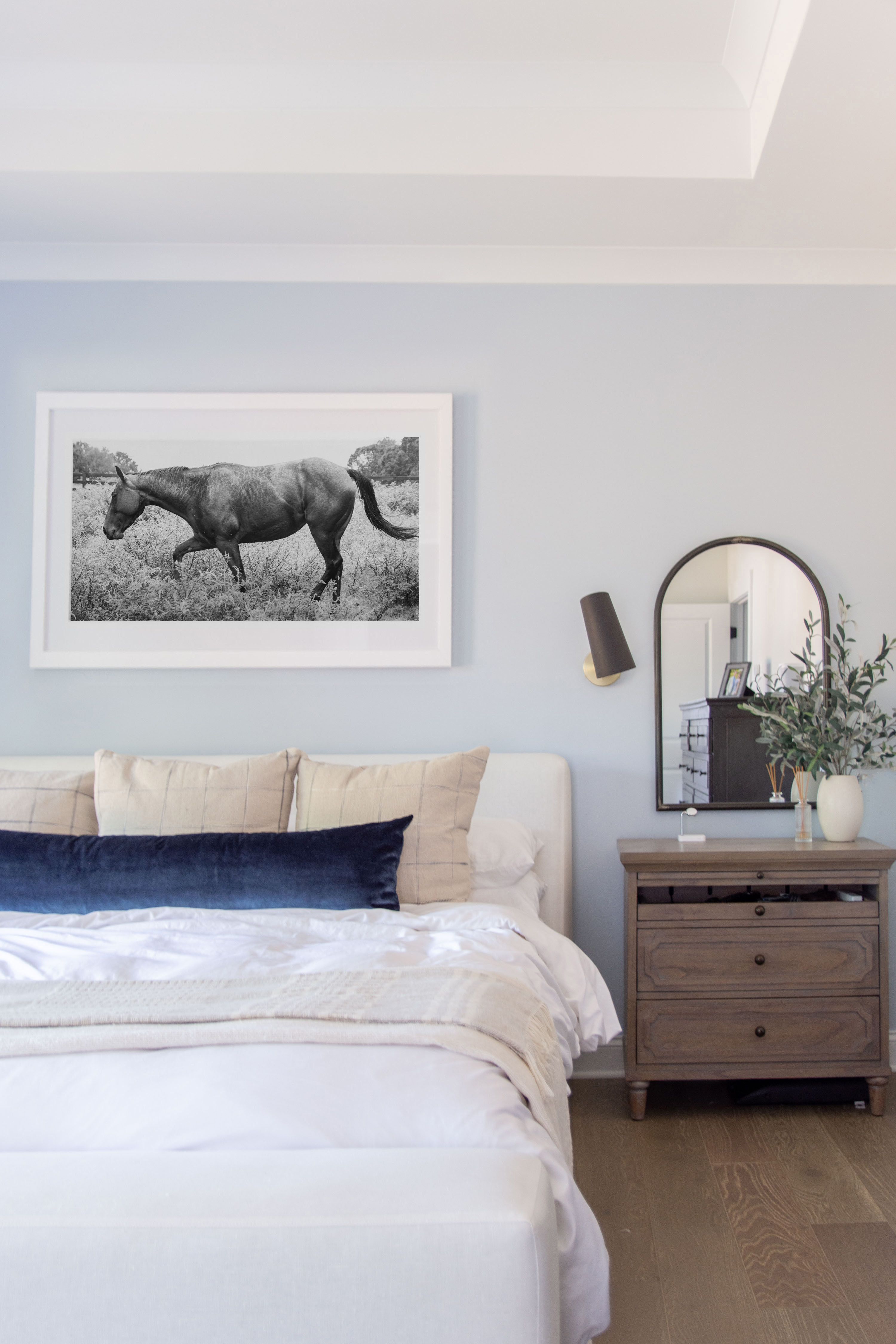 A soothing pale blue bedroom accent wall with a modern cream platform bed and charging nightstand, wall sconces, and arched mirrors, bedroom decor ideas, designer bedroom style, bedroom design tips 

#LTKHome #LTKStyleTip