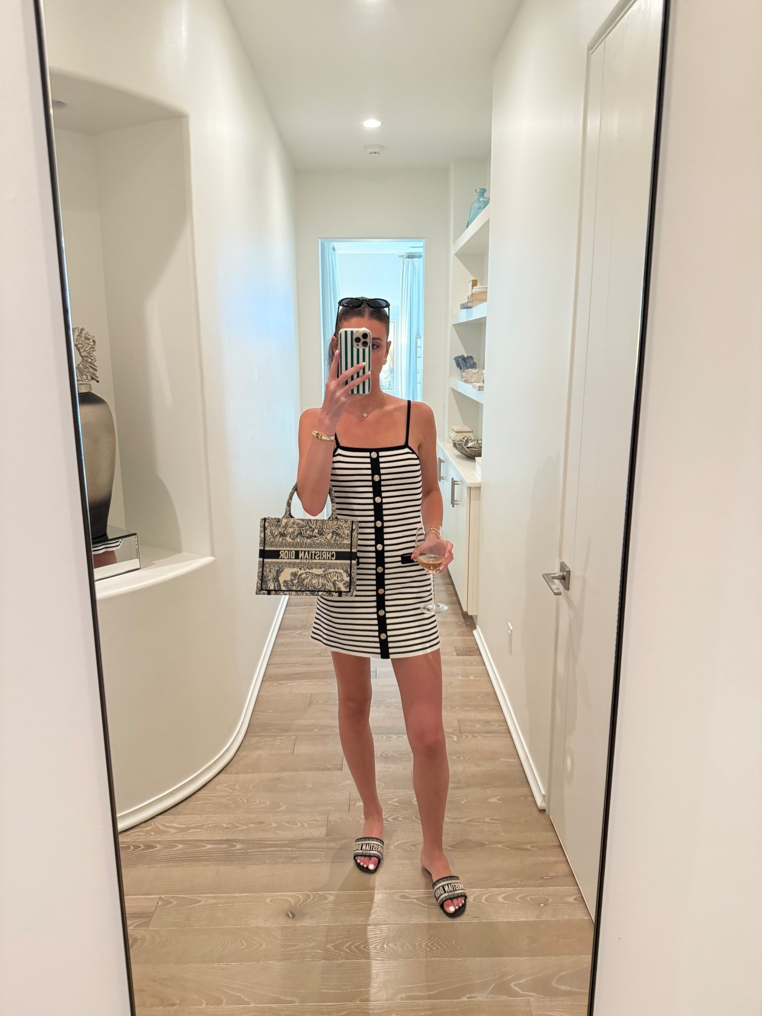 Maje black and white striped mini dress with gold buttons. Black le specs sunglasses. Black and white dior slides. Gold chunky earrings. Gold watch. Dinner outfit. Travel outfit. Vacation outfit. Preppy outfit 

#LTKTravel #LTKStyleTip