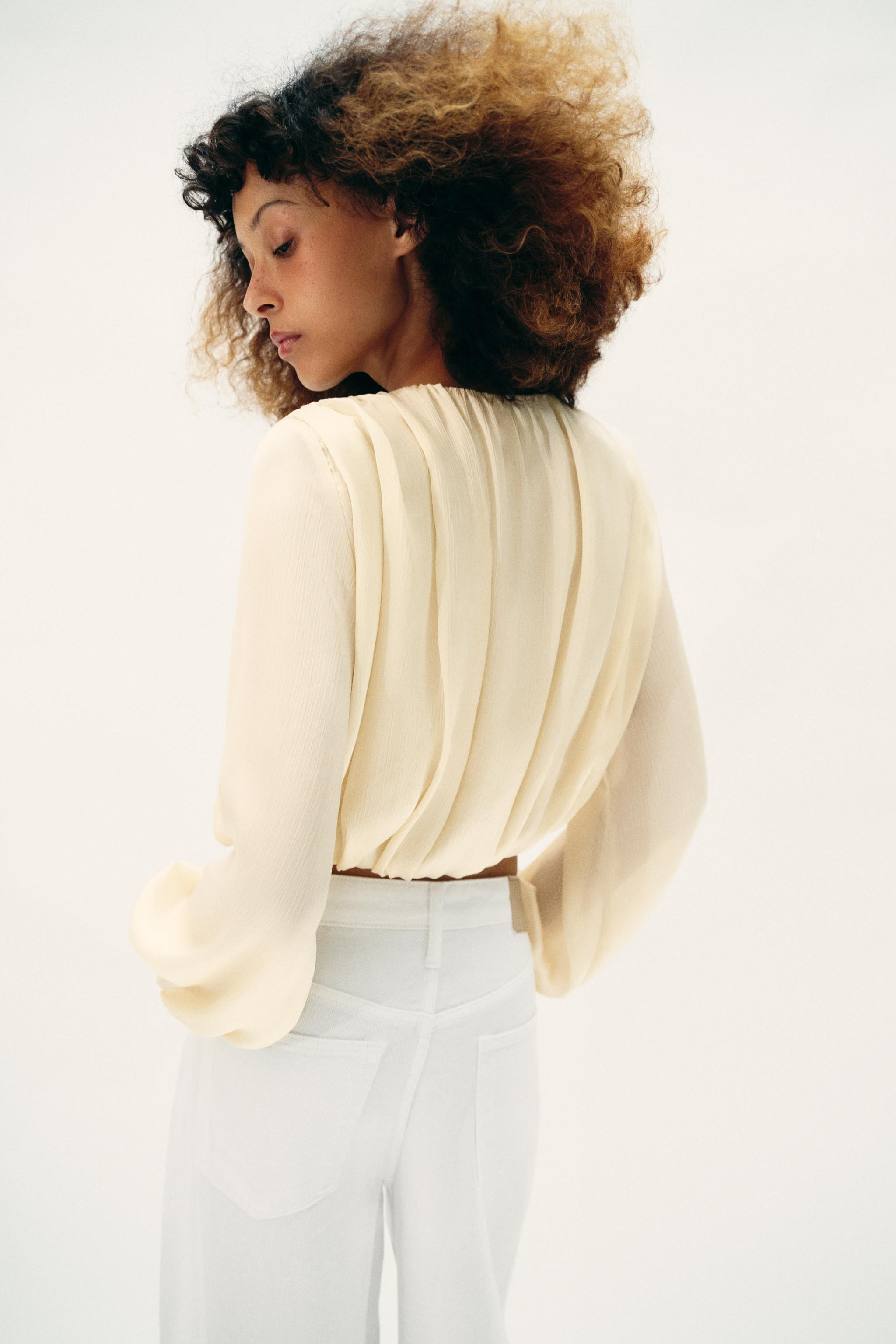 Cropped round neck blouse with a beaded drawstring. Featuring a V-neckline and long sleeves with ... | Zara UK