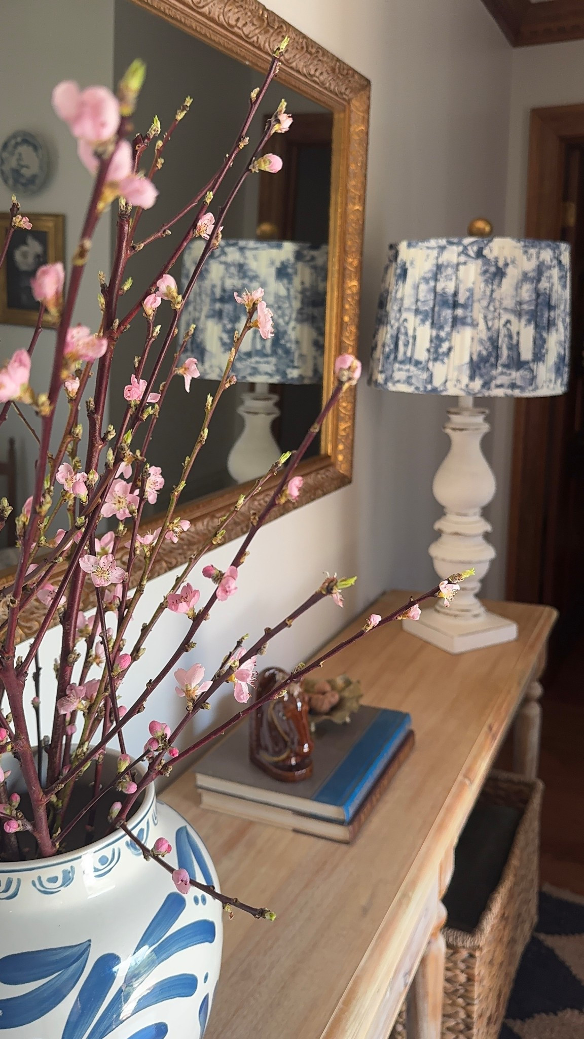 Combining a new blue & white toile pleated lampshade on an old lamp base, some thrifted finds and some forced blooms make this collected entryway spring ready  

#LTKHome #LTKSeasonal