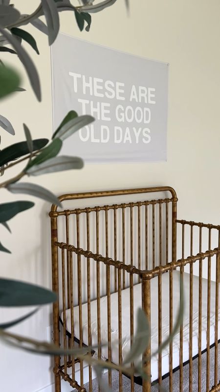 Demi’s nursery - vintage gold mini crib, Etsy These are the Good Old Days banner, boucle recliner, storage bins 