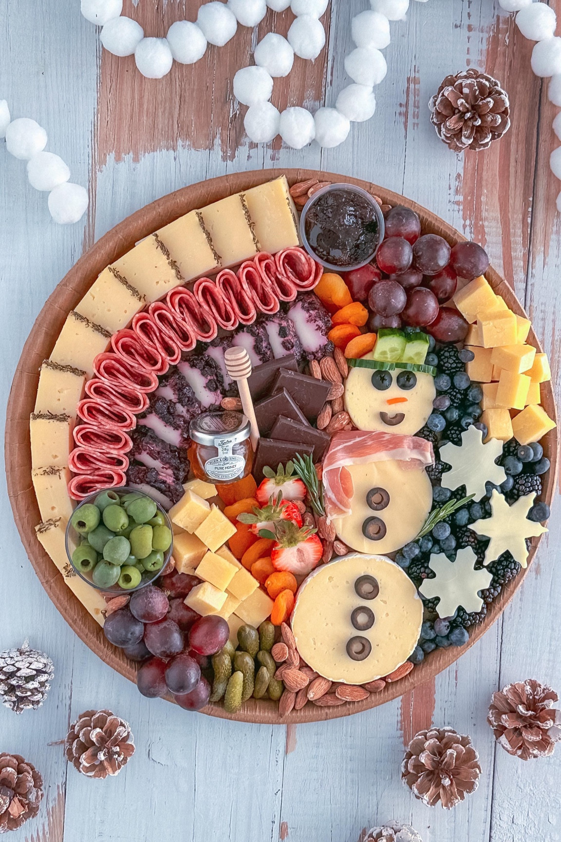 I may not be a lover of snow, but I am definitely a lover of cheese—and this snowman is one I’m excited to build! ⛄🧀

Here’s how to make your own cheesy snowman:

- Stack three different-sized cheese rounds—Brie (8oz sliced in half) for the largest base, Gouda for the middle, and a smaller Brie round or a piece cut with a cookie cutter for the head.

- No circular cheese? Use a cookie cutter to shape your favorite kinds.

- Decorate with black olives for the eyes, mouth, and buttons, cheddar for the nose, cucumber for the hat, prosciutto for the scarf, and rosemary for the arms.

#charcuterieandthings #cheese #foodstyling #charcuterieboard #fyp #snowman #doyouwannabuildasnowman