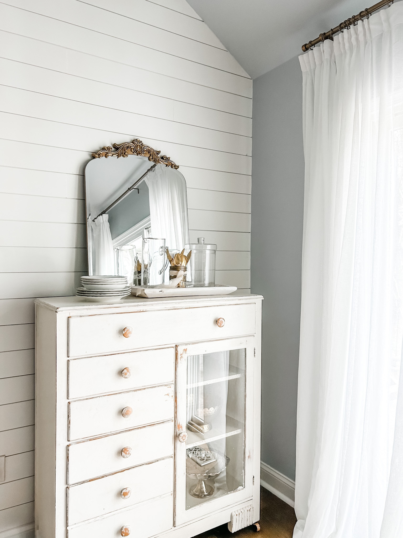 Dining room decor, buffet sideboard, white kitchen cabinet, sideboard with glass doors, kitchen cabinet with drawers, ornate gold mirror, arch mirror with beveled edge, ornate arch mirror, apothecary jar, clear glass jar with lid, Amazon drapes, pinch pleat curtains, faux linen curtains, gold curtain rod, curtain clip rings. Coastal dining room decor.

#LTKhome #LTKstyletip #LTKFind