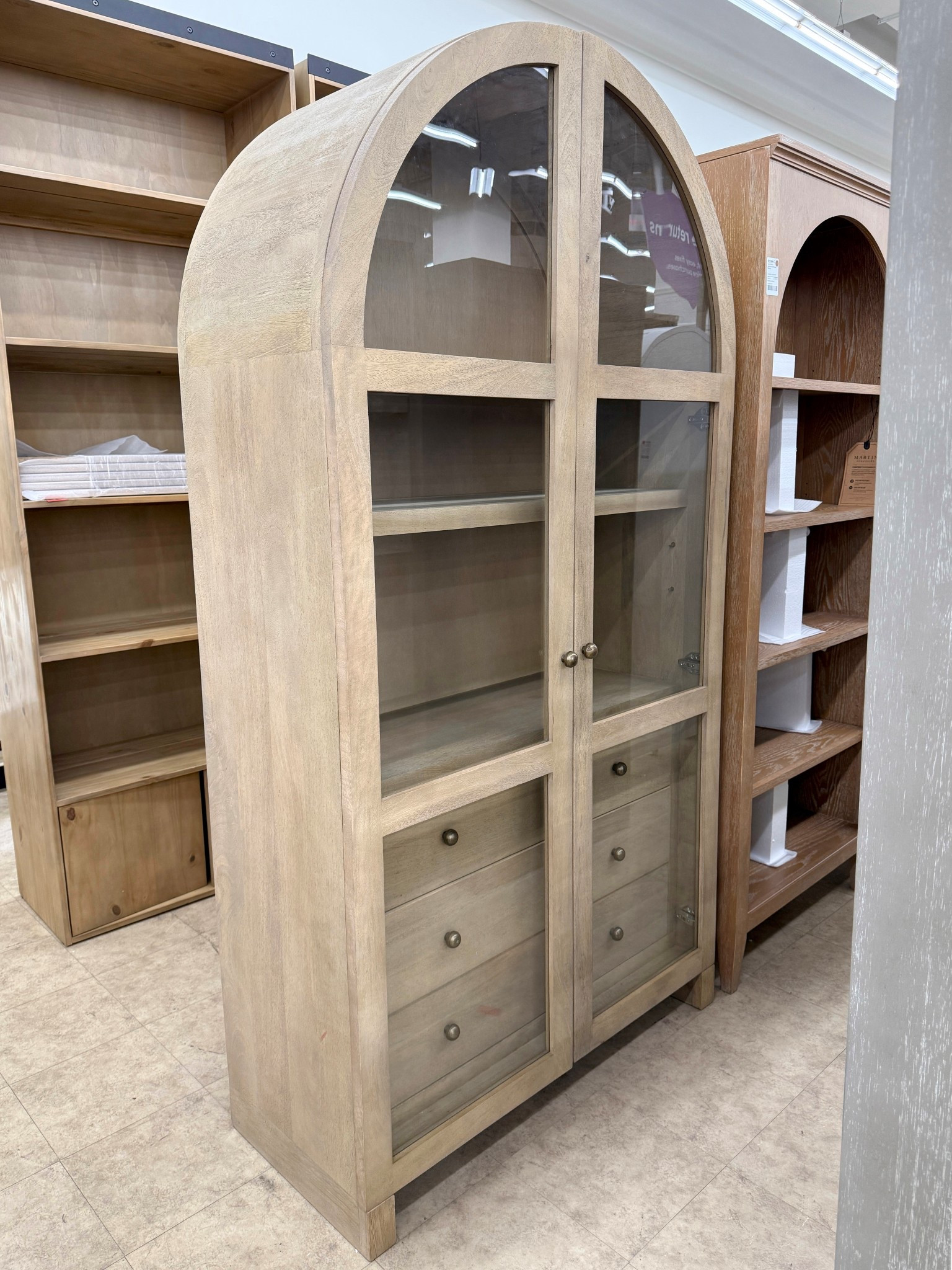 The Stonewall 80” Solid Wood Curio Cabinet from Joss & Main on Wayfair is beyond stunning! 🤎 Crafted from solid mango wood with smooth glass doors and handmade brass knobs, it feels incredibly premium and so well-made. ✨The tall arched silhouette, sandblasted texture, and neutral finish add an elegant, timeless touch to any room. With adjustable shelves and three roomy drawers, it offers beautiful, functional storage for displaying your favorite pieces. Linking this gorgeous cabinet and other arched cabinets! 💫 #ArchedCabinet #HomeDecorInspo #CurioCabinet 

#LTKHome #LTKSaleAlert #LTKGiftGuide