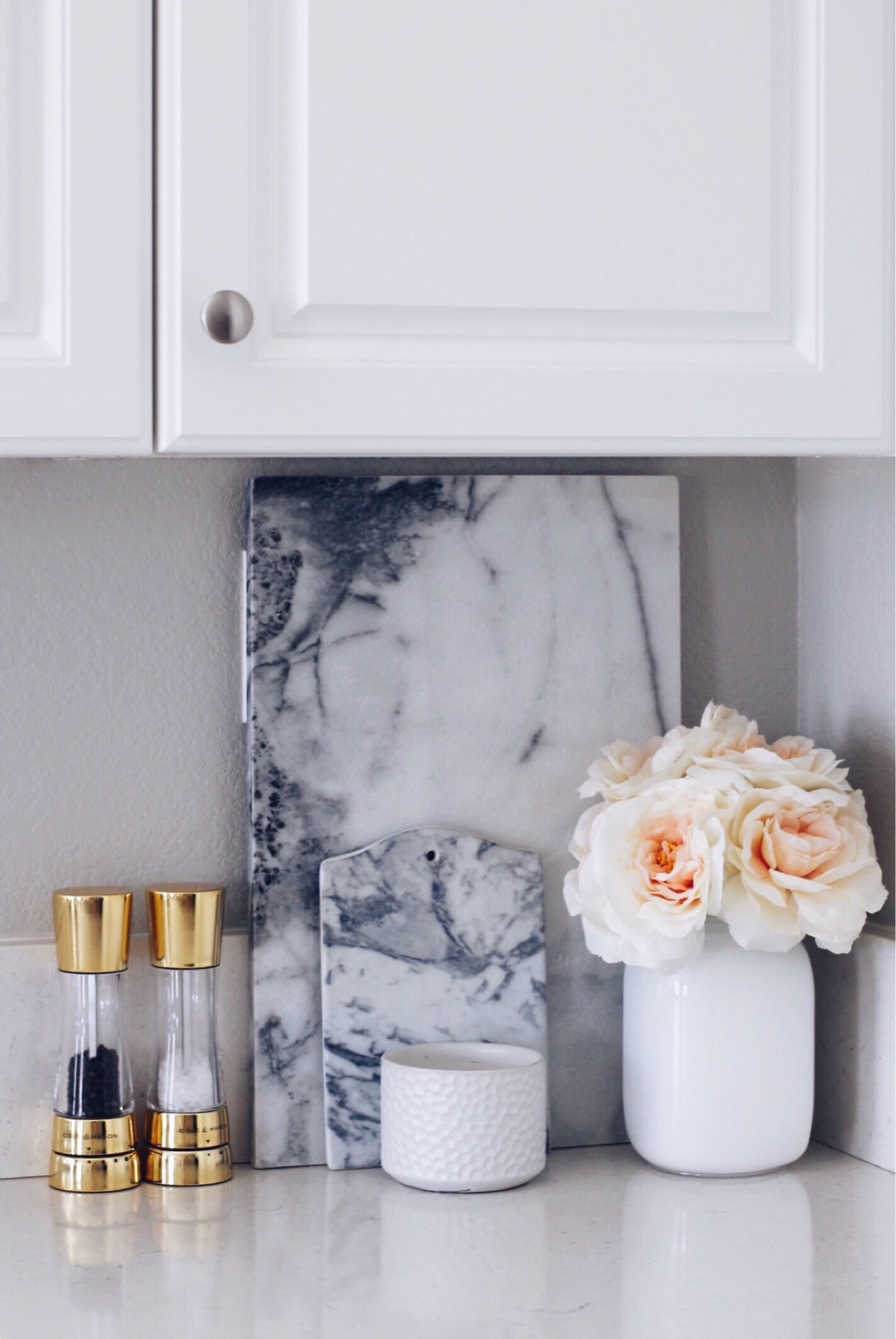 Kitchen corner styling: Quartz countertops, white cabinets, and styled with marble cutting boards, gold salt and pepper shakers, and white roses in a white vase. 

Kitchen island
Kitchen decor
Flowers
Modern home decor
Springtime


#LTKHome #LTKSpringSale #LTKFindsUnder100