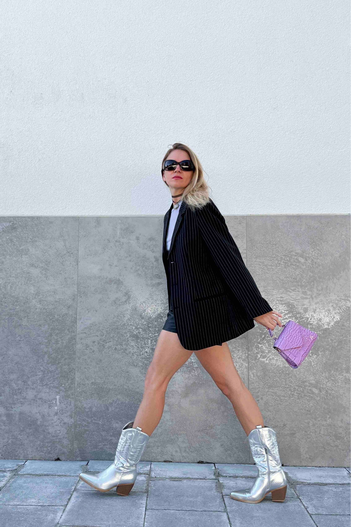 Blazer Boots. Fashion Blogger Girl by Style Blog Heartfelt Hunt. Girl with blond hair wearing a pinstriped blazer, Gucci sunglasses, heart choker necklace, faux leather shorts, purple top, purple mini bag and silver cowboy boots. #cowboyboots #oversizedblazer #silverboots #colorfuloutfit #colorfulstyle #colorfulfashion #colorfullooks #fashionfun #cutefalloutfit #fallfashion2023 #falllookbook #fitcheck #dailylooks #dailylookbook #contentcreator #microinfluencer #discoverunder20k