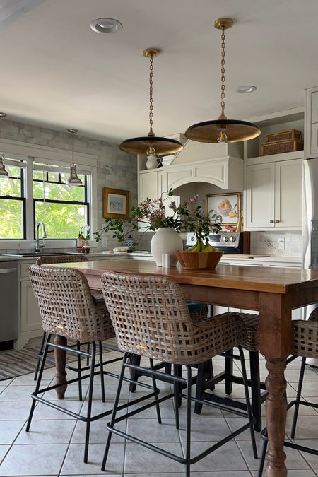 Neutral kitchen decor. With indoor outdoor woven barstools with a metal base. Beautiful, black pendants, a white vase and wood accents.

#LTKhome #LTKSeasonal #LTKfamily