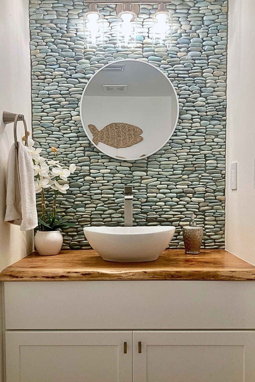 My Coastal Chic Half Bath Remodel  - This rock stone wall is the focal point of the half bathroom. My pebble stones came on 12" mesh pieces. This natural bathroom is a spa inspired bathroom. My powder room inspiration comes from nature with a relaxing but leveled up vibe with a chic spa like feel. Although I think of it as a modern coastal bathroom, it could also work for a boho or a farmhouse style half bath.  #SmallBathroomremodel #SmallHalfBathroomIdeas #affiliatelinks #coastalhalfbath #HalfBathroomRemodel #stonebathroomwall 

 #LTKHome