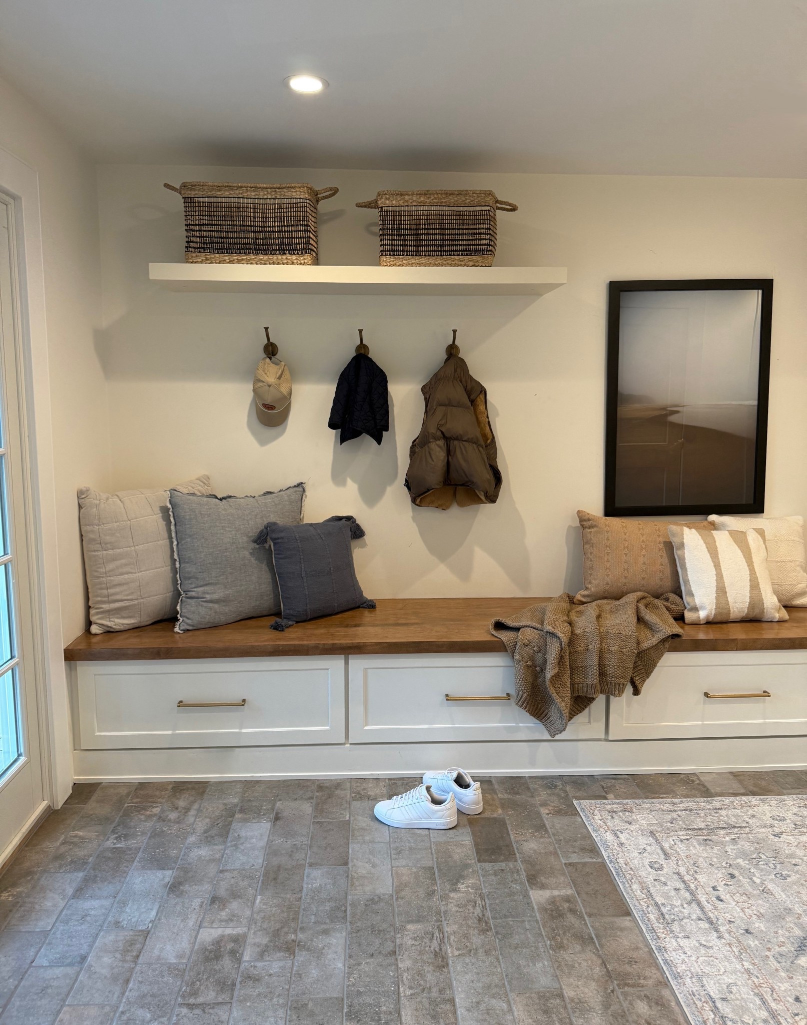 Another cozy view of the mudroom, featuring a comfortable bench with soft pillows, adding a touch of warmth and relaxation to the space. A functional spot to drop off your things as you walk in the door.
