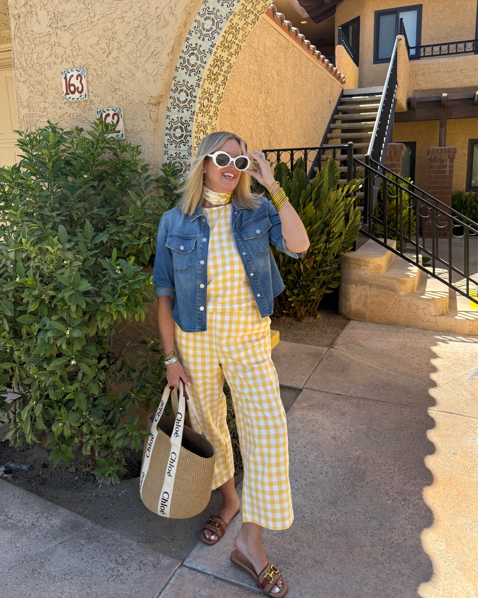 What I wore traveling from Mesa, Az to Palm Springs ..

This cute yellow and white large gingham print set.. comes in several colors and fits tts.
Pull on pant with pockets and cropped leg, cropped tank top 

Light weight denim jacket, perfect for air conditioned rooms etc 

Easy spirit cane and leather horse bit detail slides with cushioned sole on sale under $50  so comfortable 

My go to summer straw tote by chloe
Perfect for pool or travel holds everything from towel, book, laptop to a full outfit and toiletries!

Fun white rimmed sunnies a great Amazon find

Yellow scarf around neck mine is free people older linked similar 

Budha girl gold bangles set

#LTKootd #LTKdayinmylife #LTKTravel