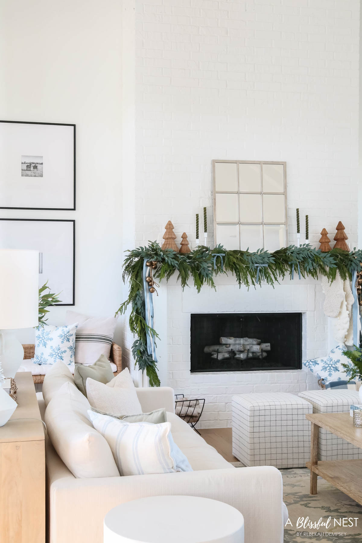 Create a classic Christmas feel without the fuss. Shop everything you need now.
blue velvet bows, woven Christmas cone tree, Norfolk Pine Christmas garland, olive green taper candles, candlestick holders, dusty blue satin ribbon, ivory velvet ribbon, vintage cluster cow bells on rope, upholstered cube ottoman, fairy lights, rattan bench, snowflakes pillow, cream stripe pillow, cream sofa, green throw pillow, textured cream throw pillow 

 #LTKHoliday #LTKSeasonal #LTKHome