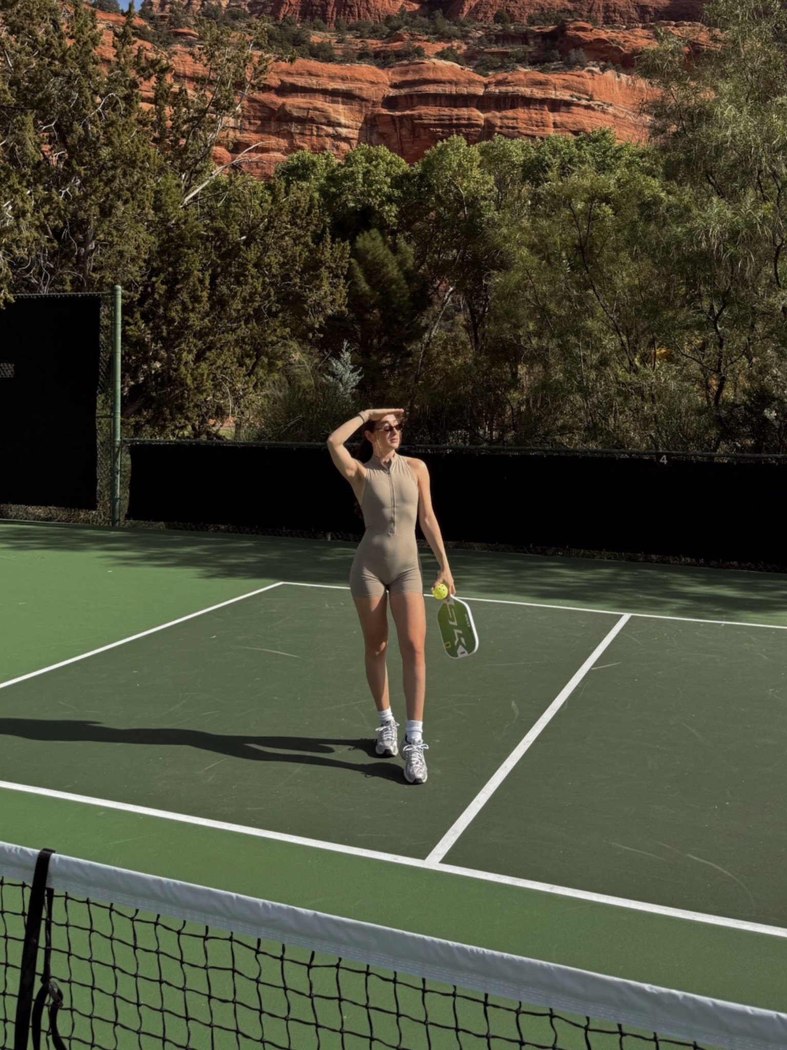 Neutral tennis court moment in the desert 🤎
Wearing a neutral workout romper (size small) with New Balance sneakers (7.5) – such an easy one-piece outfit for travel days, hot girl walks, and court-to-coffee plans in Page, AZ.

neutral workout romper · one piece activewear · athletic romper · tennis outfit · pickleball outfit · neutral gym outfit · New Balance sneakers · New Balance outfit · sporty chic outfit · athleisure look · summer activewear · travel outfit inspo · desert vacation outfit

#LTKActive #LTKselfcare #LTKPetite