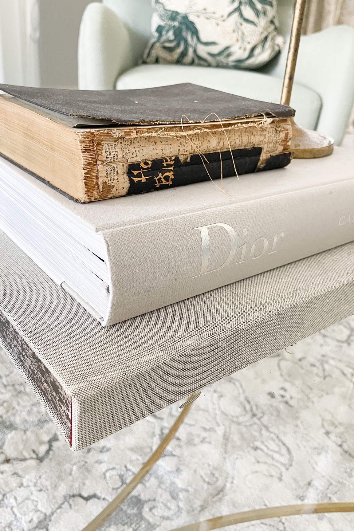 Living room vignette 
Coffee table book 
Gold taper candle holder 
Gold glass coffee table 
Arm chair wingback 

#LTKsalealert #LTKstyletip #LTKhome