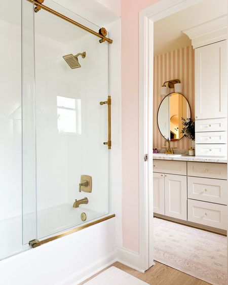 Get inspired by this dreamy Girls' bathroom design – Featuring a sleek shower glass enclosure & vibrant pink accents. Click through to see the hilarious art that I chose for the space, it adds a fun touch to the whimsical pink bathroom. The T Rex on the toilet gets me every time! #bathroomremodel #girlsbathroom #kidsbathroom #showerglass 

#LTKhome #LTKfamily #LTKkids