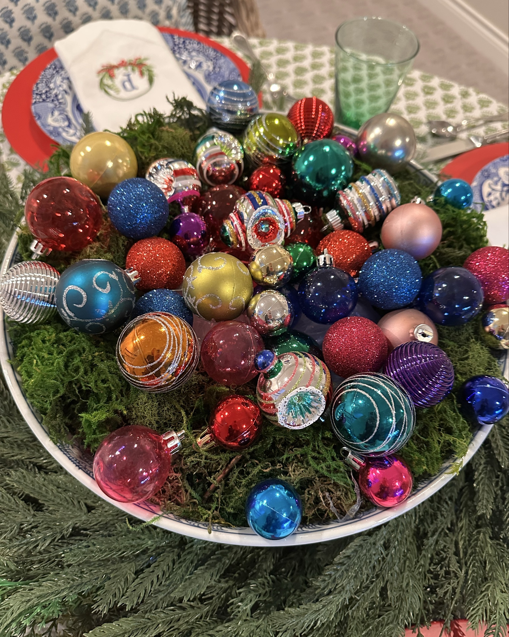 Here’s an easy to throw together festive Christmas tablescape and centerpiece. I started with a big blue and white bowl that used to have orchids in it. I filled most of it with leftover plastic wrapping  from Christmas gifts and then covered it with some green moss. I scattered different ornaments over the top. It’s that easy! The fun block print tablecloth and my traditional blue and white Spode with monogrammed napkins make for an extra happy table!🎄🩷♥️

#LTKdayinmylife #LTKHome #LTKHoliday