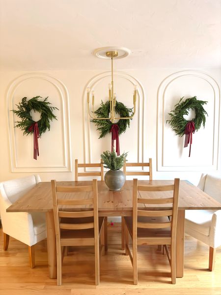 Three fake Norfolk, Pine Christmas wreaths hung in my dining area being my gold chair
