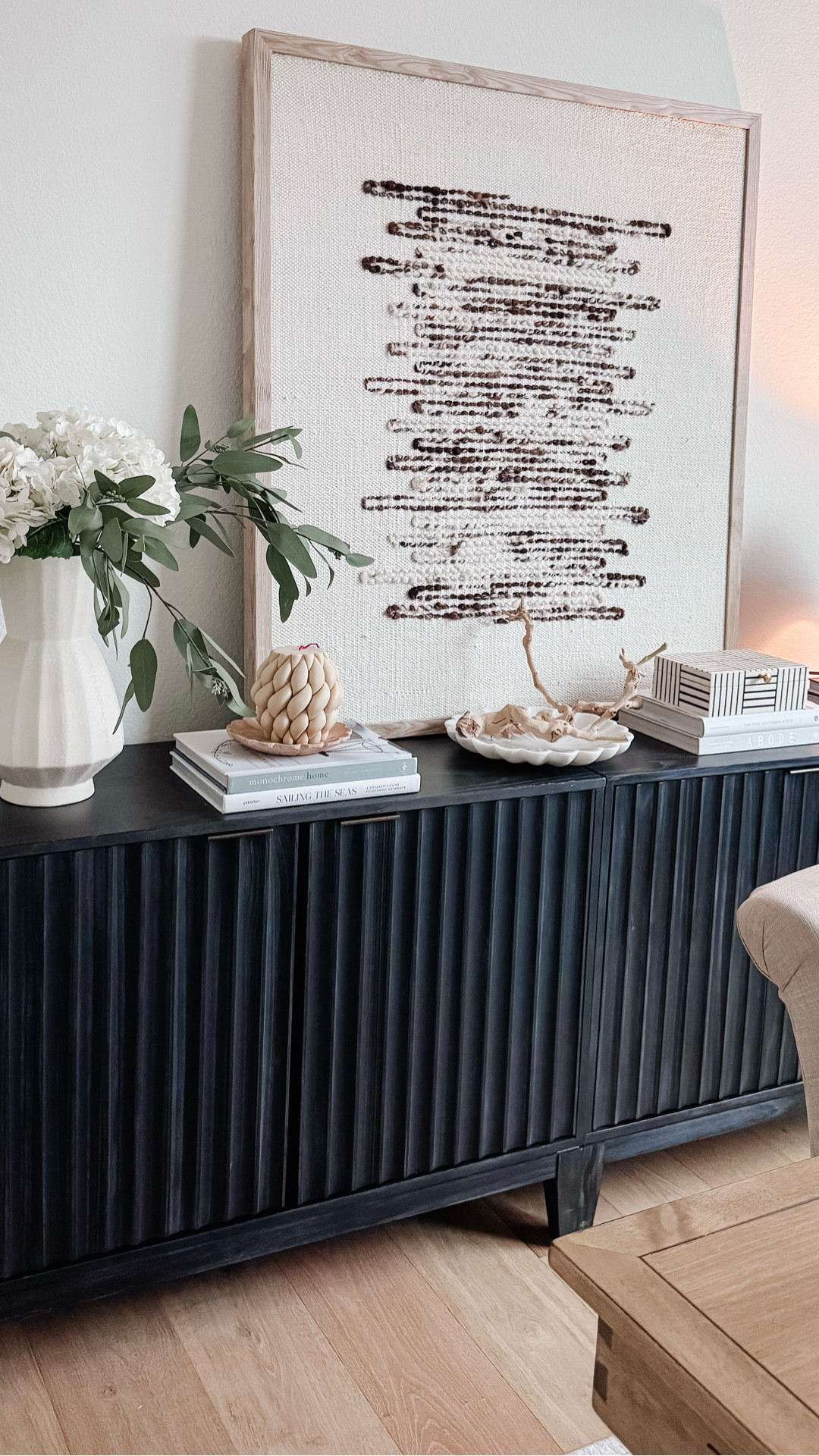 Save this for console table styling inspiration. This neutral console table styling is one of my favorite ways to add warmth and texture to a living room. I styled this black fluted console with layered books, hydrangeas, greenery, and a warm lamp for an elevated designer look that still feels simple and livable. Console table styling like this works beautifully in a living room, entryway, or behind a sofa and is an easy way to refresh your home decor with neutral pieces that never go out of style. I linked everything from the console table to the vase, hydrangeas, lamp, and decor accents so you can recreate this neutral console styling in your own space.

#LTKSeasonal #LTKHome #LTKSaleAlert