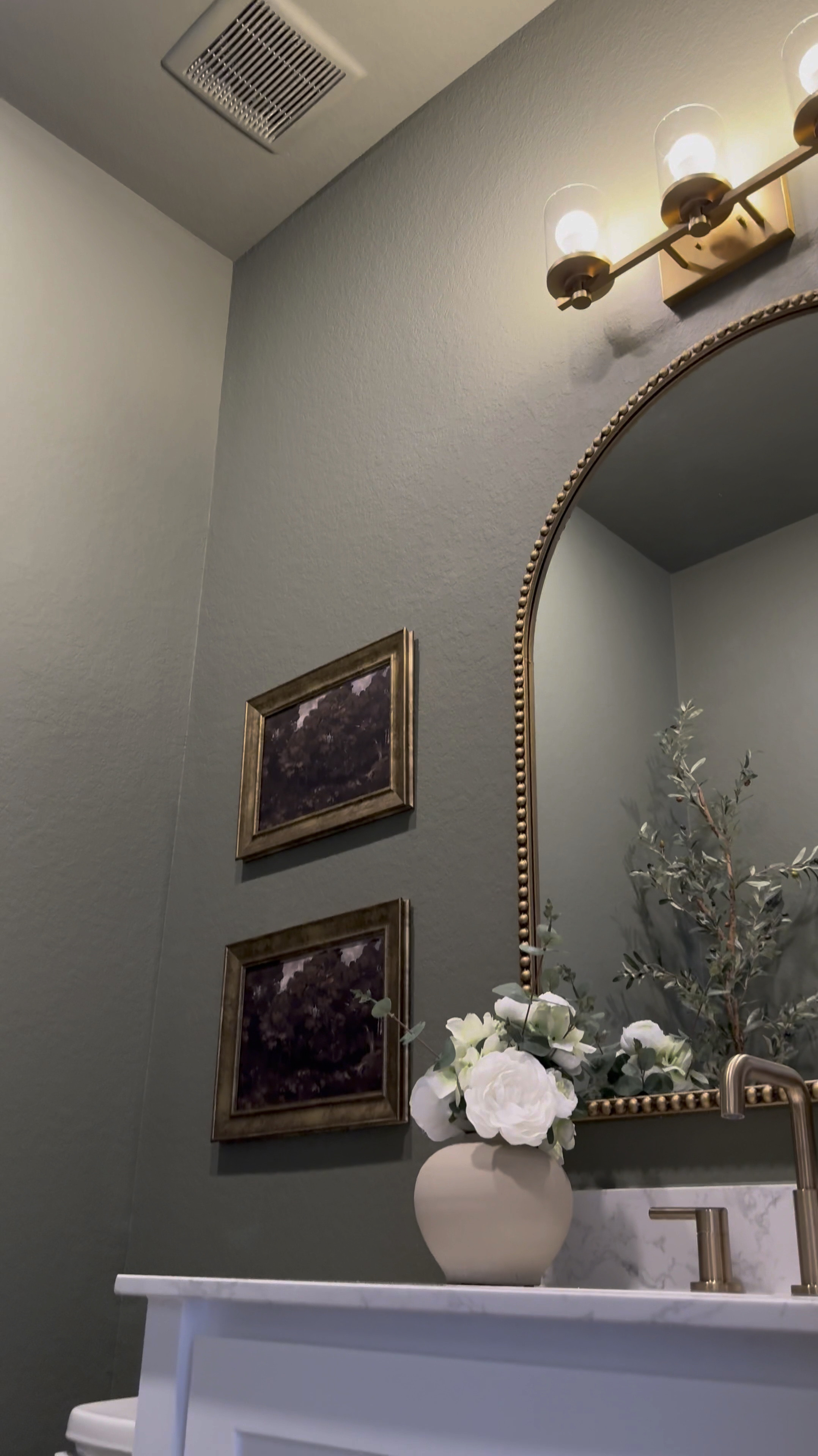 Comment: Bathroom

If you’re considering painting your powder room green, I’m telling you, THIS might be the perfect color for you … go for it! 

I used flat finish for the walls and painted the baseboards in satin finish… 

I’ll be honest, I was apprehensive at first … I even paintings the ceiling 😬 believe it our not, it made the room feel larger! 

I chose brass finishes bc I really wanted the space to have a vintage feel… well, modern vintage…??? If that’s a thing 😆.. 

The mirror is 30x40 inches… 

I added a new light fixture and it now faces upwards … which made that wall feel taller 

I wasn’t in love with this builder grade vanity tbh😆, matter-fact, I wanted to change it… it wasn’t functional …but now i wanna keep it lol 😂… I added brass hardware, these cute baskets from Walmart, led light strips on the bottom and now it’s a whole new unit….. you can even add battery powered/rechargeable/plug in led light strips .. whatever fits your lifestyle 

Ok let’s talk about this stunning planter!!! …. You know I love me an olive tree 😆… and I wanted something tell and slim… this planter was the perfect for plus it added to the moodiness 🥰

I am in love with this space… I wanted to create a vintage-cottagy feel in this powder room, while the rest of the home feels modern. 

#LTKStyleTip #LTKVideo #LTKHome