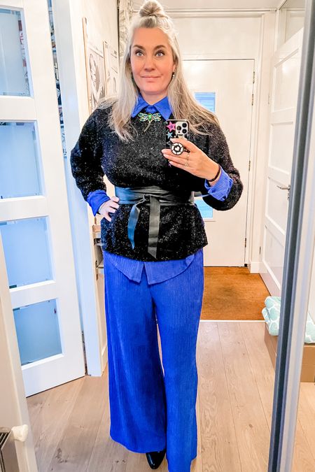 Ootd - Tuesday. Royal blue comfortable co-ord set consisting of a button down shirt and wide legged pants (elastic waist). Wearing a large/tall. Black glitter sweater, strass dragonfly brooch, wrap belt and pointy toe boots. 

#ltkgift 

#LTKover40 #LTKworkwear #LTKmidsize