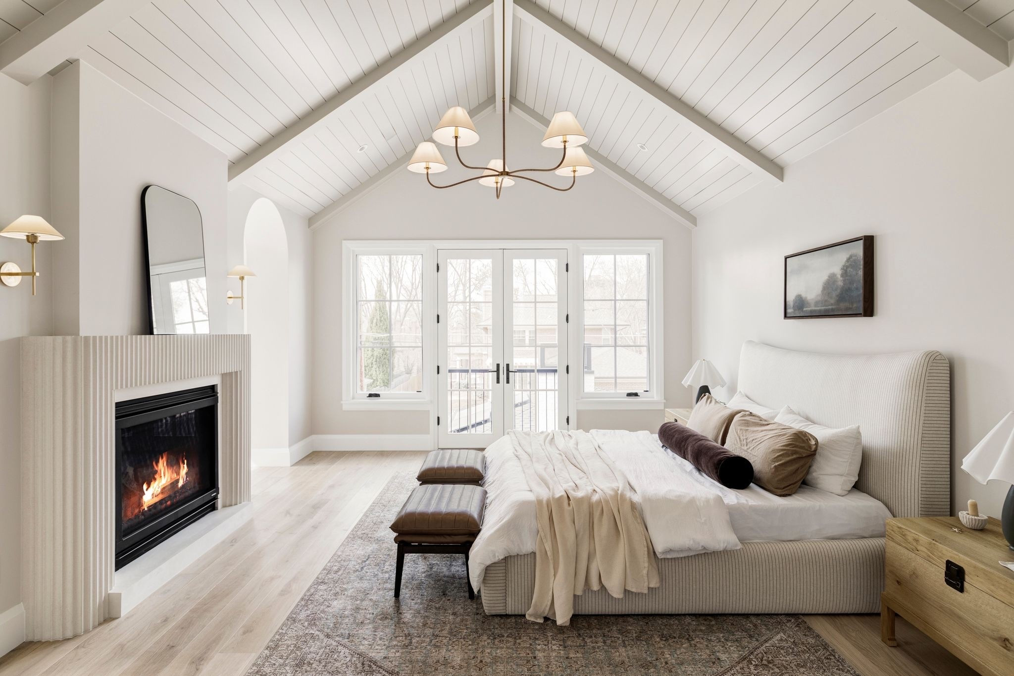 An upholstered bed, light oak nightstands, and leather ottomans create a bedroom that feels both refined and comfortable.

Bedroom, bedroom rug, bed, McGee and co, amber interiors, trunk, nightstand