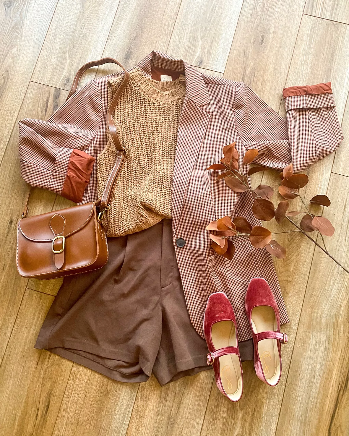 a neutral sweater, a green leather midi skirt, an orange vintage bag and  plaid flats