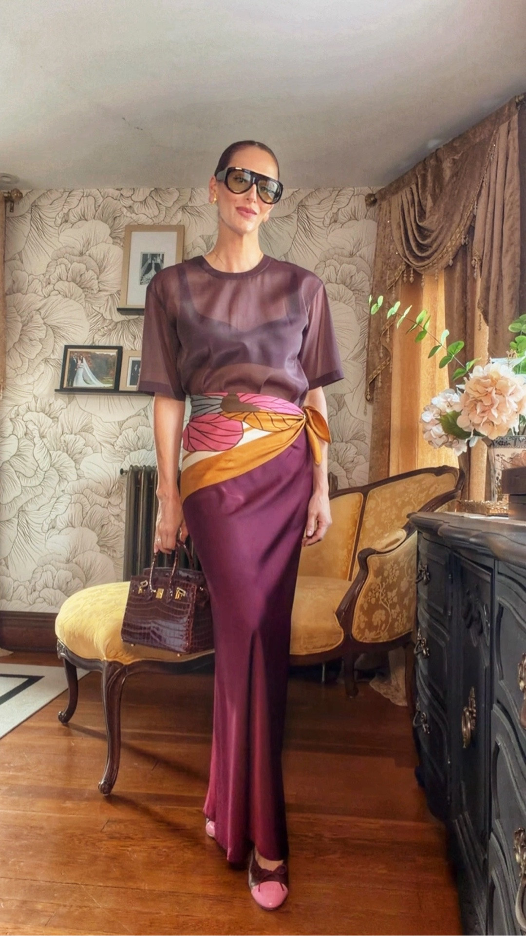 Burgundy, but make it interesting. The sheer tee + satin maxi creates the tonal base, while the vintage silk scarf worn as a belt breaks up the monochrome and adds just enough print.

Finished with pink ballet flats, an oversized aviator and a structured bag—proof that accessories can completely change the direction of a simple outfit formula.

#LTKStyleTip #FallStyle #BurgundyOutfit #ScarfStyling #PersonalStyle #FallOutfitInspo #BalletFlats