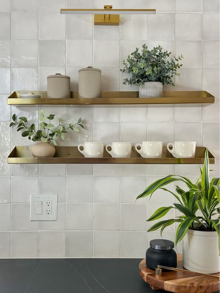 Gold metal floating shelves in kitchen with battery powered picture light. Zellige tile. White coffee mugs.

#LTKhome