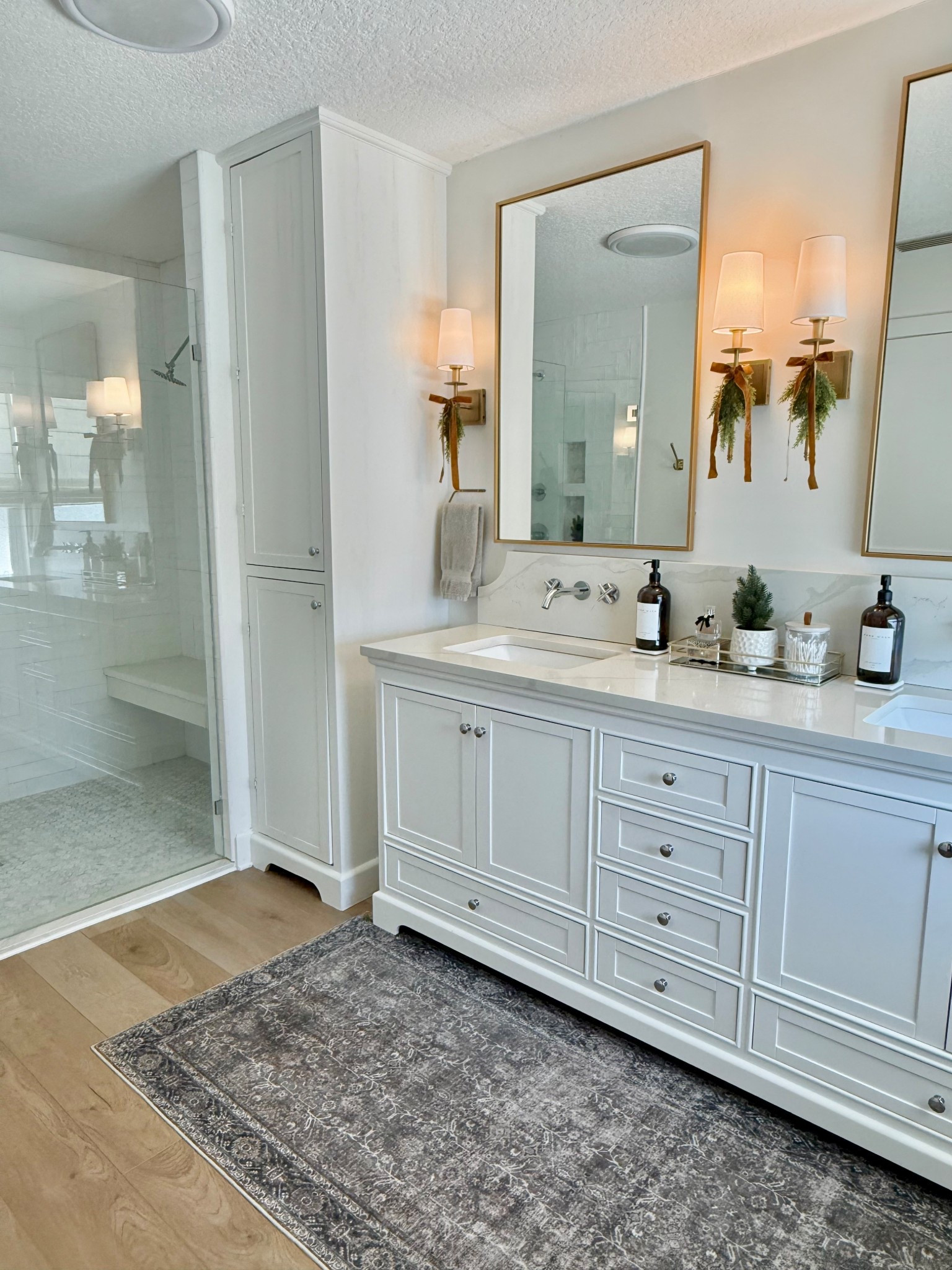 Primary bathroom white double vanity sconce lighting brass hardware fixtures soap dispensers amber glass machine washable rug 

#LTKFindsUnder100 #LTKHome