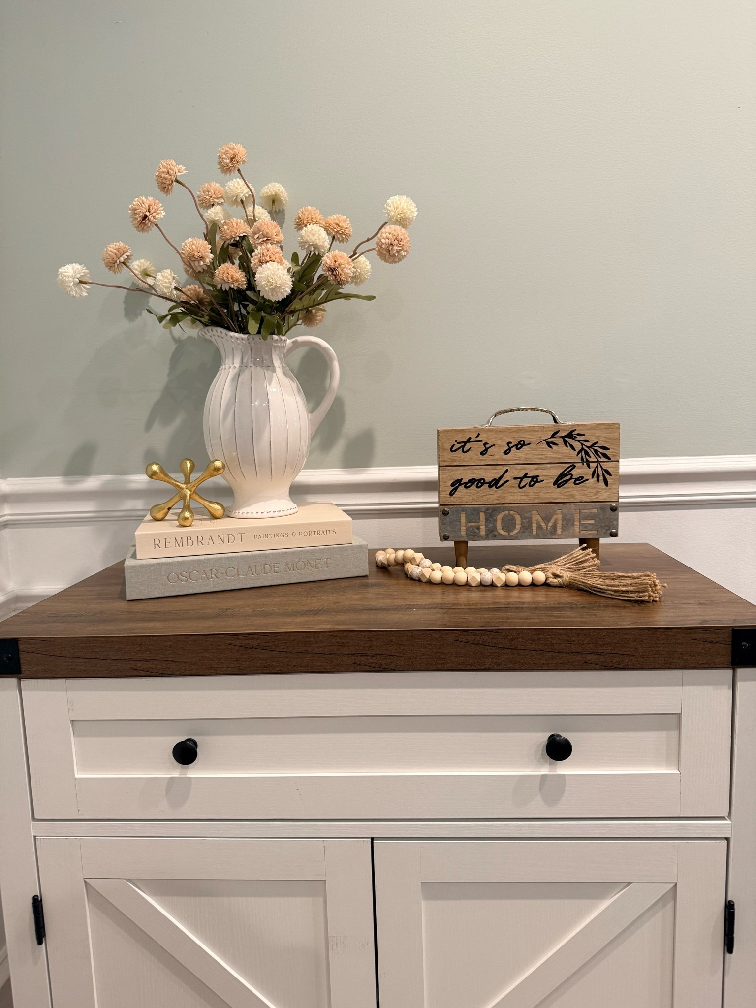 Styling dining room accent table / cabinet with storage 
Faux books and faux silk mums in a pretty white pitcher