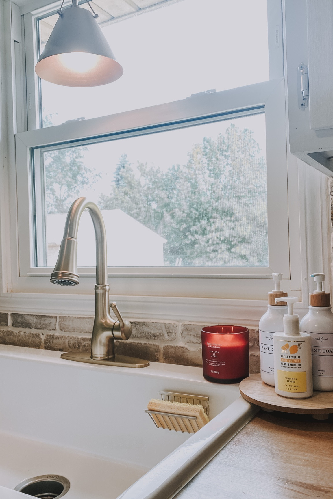 Gold Faucet | gold pendant | clean cottage kitchen | white | brick | farmhouse sink