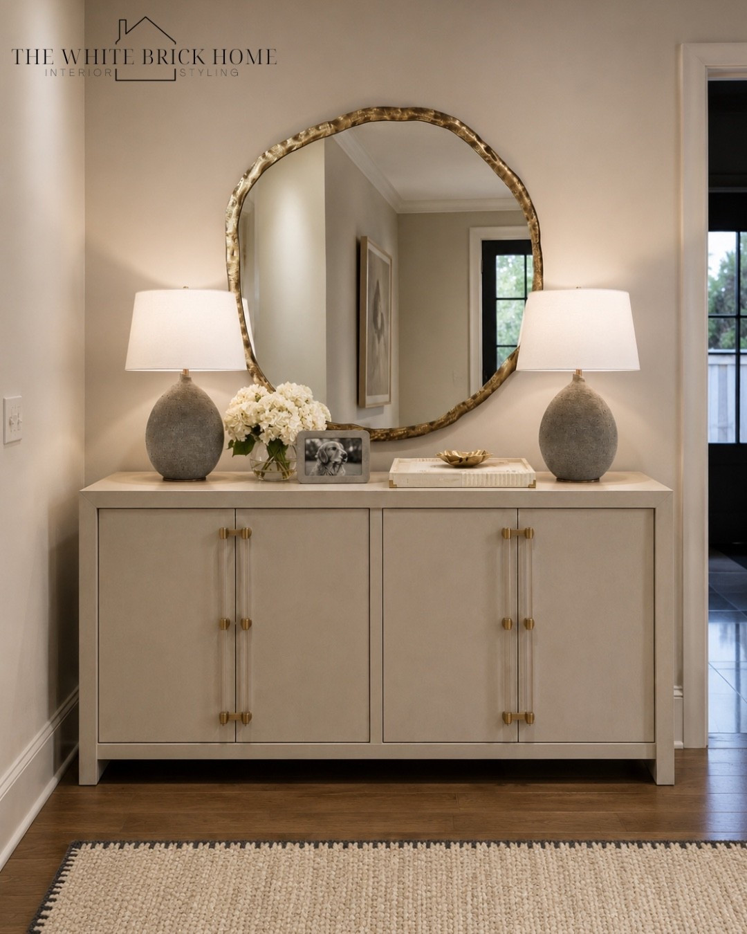 Warm neutrals and layered texture create an effortlessly elevated table styling that feels polished and inviting. 

Entryway, console table, wall mirror, table lamp, tray, home decor, home accessories, home design, living room, living room design, console table, table styling, cb2, lumens