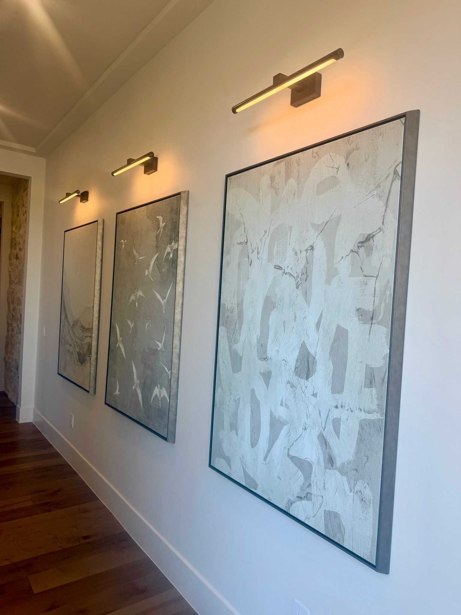 I added these picture lights above the artwork in our hallway and they completely changed how this wall feels. The slim design gives a soft wash of light across the frames and makes the artwork feel more intentional.

I like using picture lights like this to highlight large art pieces or create a simple gallery wall moment. Linking the picture lights and a few similar pieces here if you’re looking for an easy way to elevate wall art.
 @Wayfair 
 @Lulu and Georgia 
@Amazon

#LTKU #LTKHome #LTKSaleAlert
