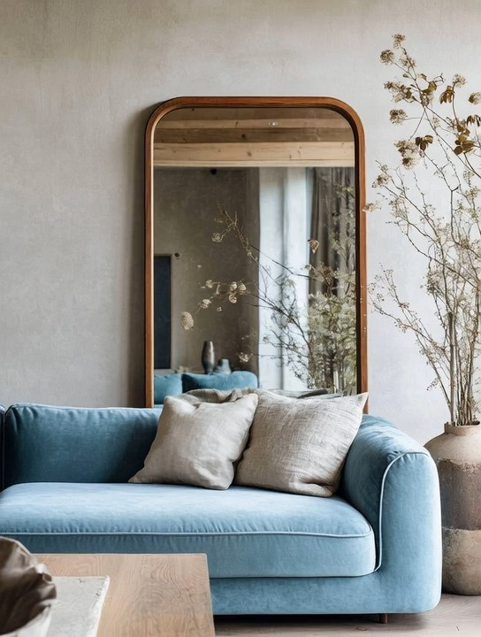 Minimalism doesn’t have to feel cold or boring—and this space is the perfect example of soft, elegant minimalism done right. A light blue velvet sofa instantly brings warmth, texture, and personality to a neutral room, while still keeping the overall look calm and refined. Velvet adds that subtle sense of luxury without overwhelming the space, making it ideal for modern, minimalist, and European-inspired interiors.

Pairing the sofa with a wood-framed or antique gold frame mirror creates balance and visual depth. The mirror reflects natural light, makes the room feel larger, and adds an architectural element without adding clutter. This combination works beautifully in a living room, sitting area, bedroom lounge corner, or even a stylish home office waiting area. Keep the rest of the styling intentional—neutral cushions, natural wood accents, soft textures, and a restrained color palette.

The beauty of this look is that it feels curated yet effortless. It’s minimal, but not empty. Elegant, but still livable. By mixing soft color, tactile fabric, and timeless materials, you create a space that feels serene, modern, and quietly luxurious—proof that minimalism can still have soul and character.

#modernminimalism #velvetsofa #eleganthome 

 #LTKHome