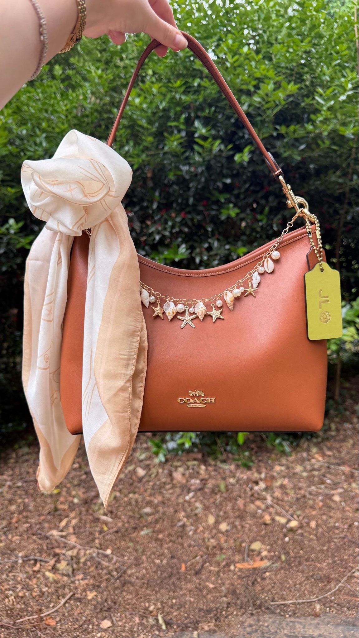Coach outlet Laurel with large square scarf tied into a flower, shell chain. Green tag made at Coach