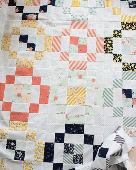 Jelly Rings quilt pattern using a Riley Blake Daybreak Jelly roll plus Swiss dots background.  Quilt pattern available in the Quilty Love pattern shop. 
