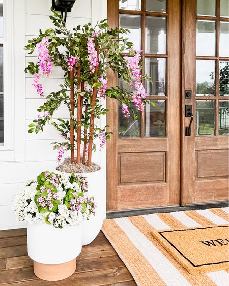 Spring Front Porch!! Loving these wisteria trees! Use BRUNOANDLIBBY for 30% off at nearly natural! Jute rug is 4x6. Front porch and front door decor large white planter trending viral home decor pottery barn dupe look a like look for less artificial faux plants trees flowers florals greenery modern farmhouse southern porch lantern, outdoor light fixtures, wall sconces lighting silk faux flowers d geraniums, hydrangeas kalanchoes pink florals jute rug scatter rug welcome mat doormat, double layered

#LTKSeasonal #LTKhome #LTKstyletip