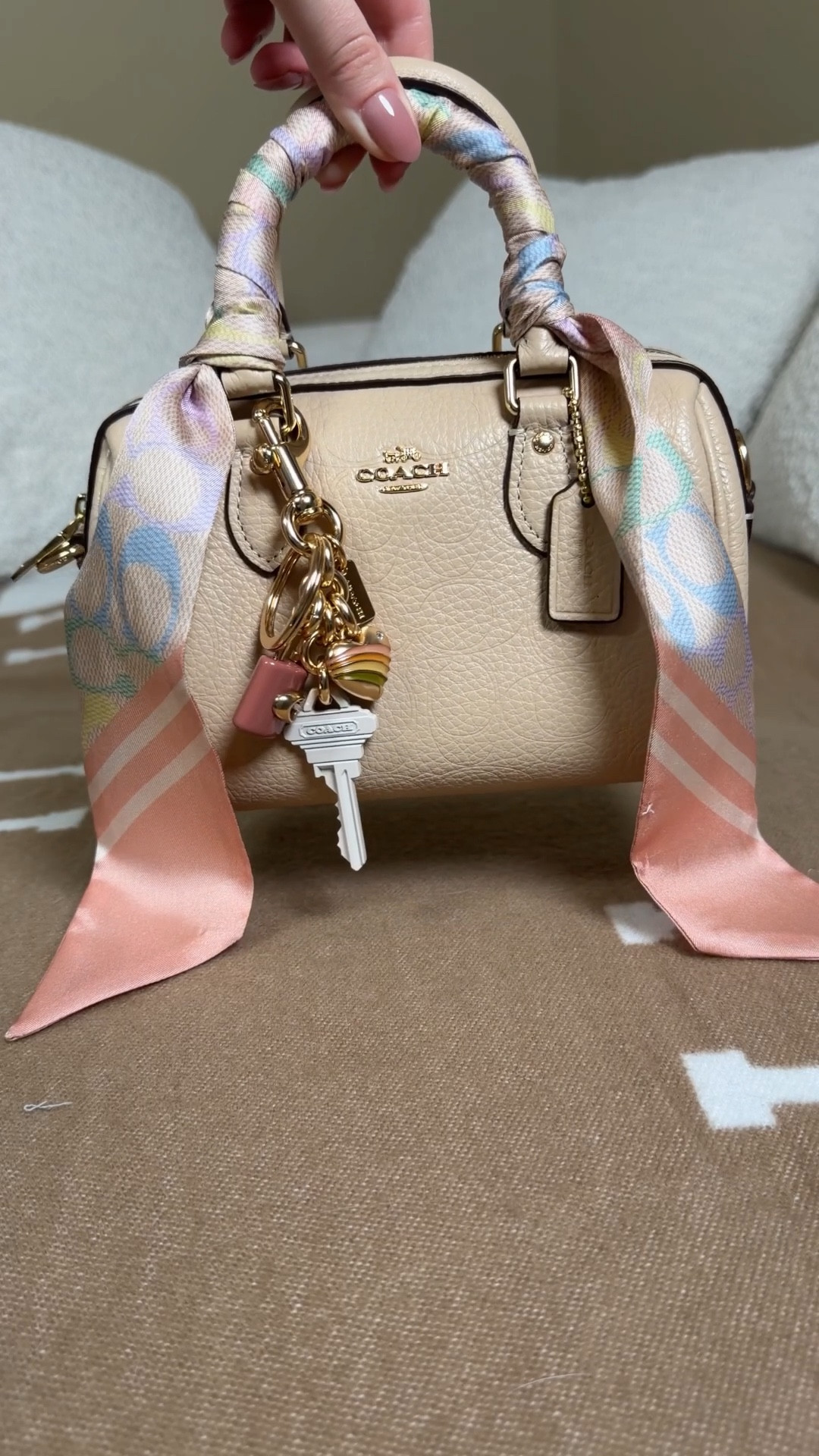 Unboxing one of the new mini Rowan bags form the latest Coach outlet collection 💗 Comment BAG & I’ll dm you the links to everything 🌸

This cream colored mini crossbody Rowan is the perfect bag to carry into spring 🌸 I’m not a colorful bag girly but this beige color is perfect to add fun colorful touches to like this coach signature rainbow pattern Twilly and the pastel lock and key heart bag charm 

Signature refined pebble leather and refined pebble leather
Fabric lining
