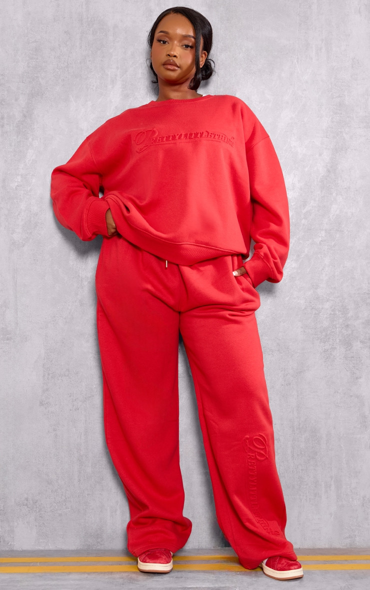 PRETTYLITTLETHING Plus Red Embossed Graphic Straight Leg Sweatpants | PrettyLittleThing US